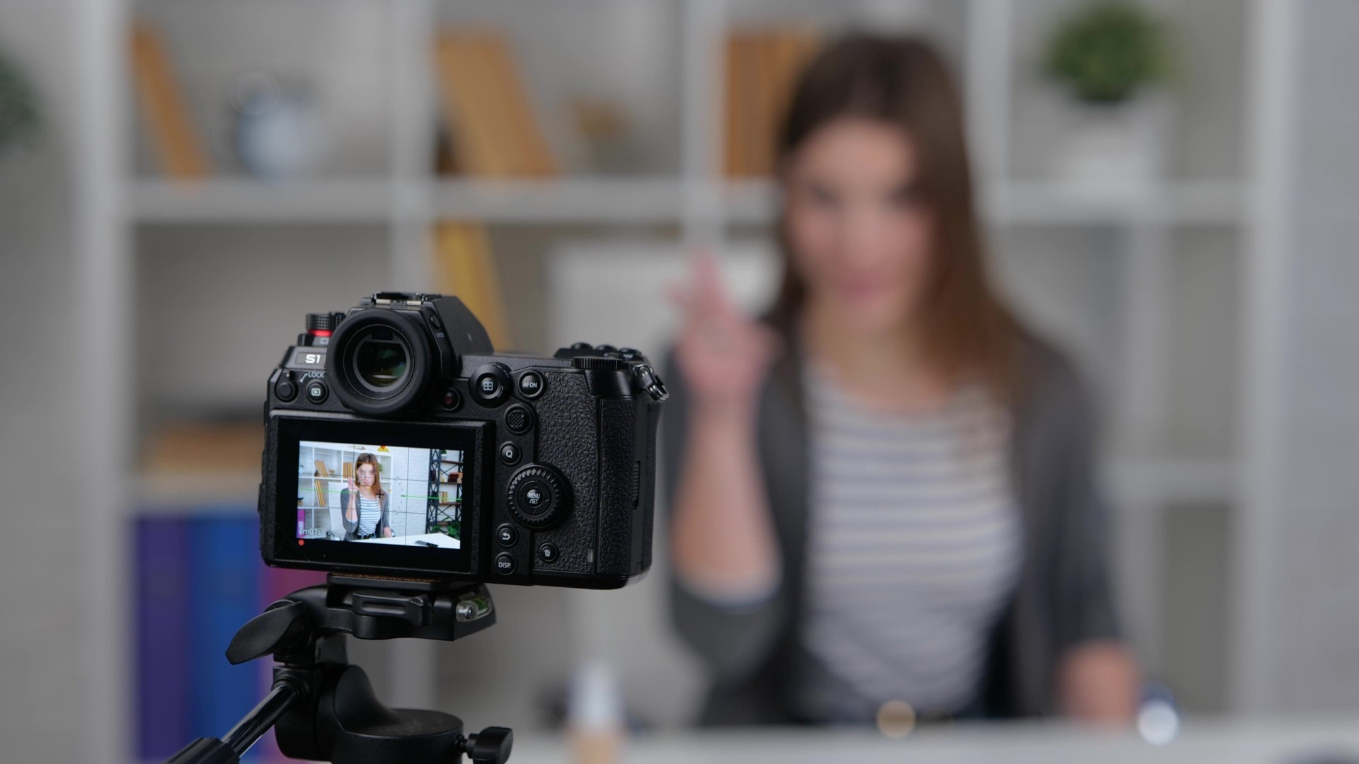 Display of camera recording video blog. Female media influencer showing dollar banknotes to followers. Slow motion video. Vlogging concept